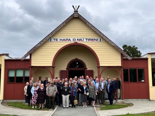 A group of people standing in front of a building

Description automatically generated